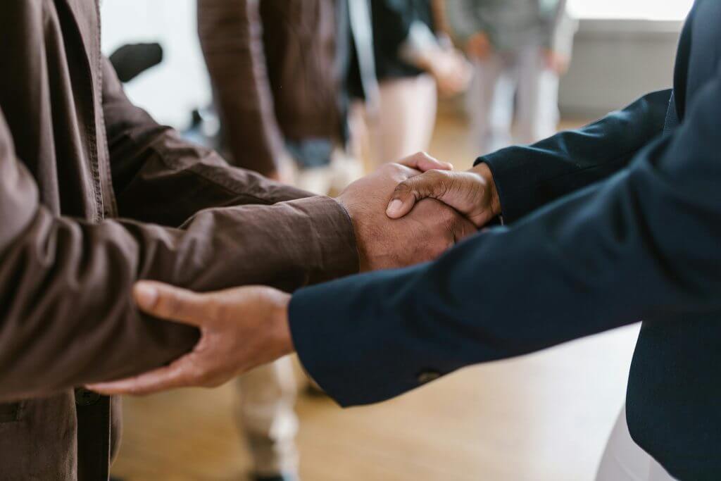 Two business professionals shaking hands after a successful B2B partnership deal